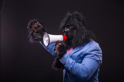 businessman wearing gorilla mask and screaming to megafon-stock-foto