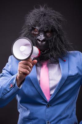 businessman wearing gorilla mask and screaming to megafon-stock-foto