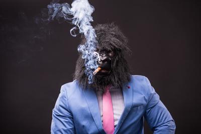 businessman wearing gorilla mask and smoking cigar-stock-foto