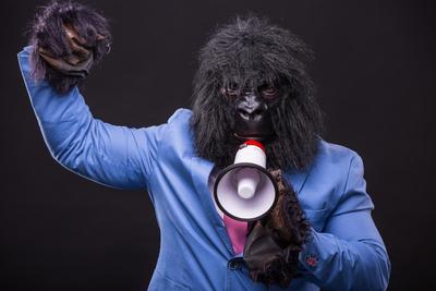 businessman wearing gorilla mask and screaming to megafon-stock-foto