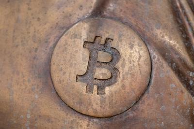 a bitcoin icon on a bronze statue-stock-foto