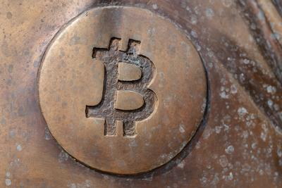 a bitcoin icon on a bronze statue-stock-photo