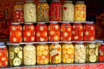 Nagy befőtes üvegek, dunsztos, teli ecetes paprikával, tökkel, karfiollal-stock-foto