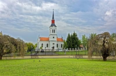 Szécsény, evangelikus templom vas kerítéssel és fűz fákkal-stock-photo