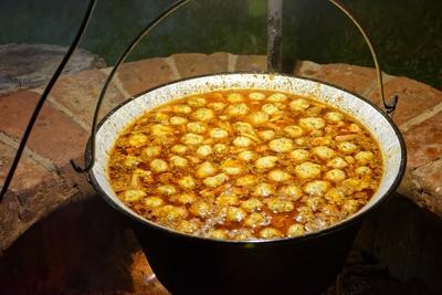 Tárkonyos, vargányagombás, nyírségi krumpligombócos, lestyános marharagu leves a bográcsban, Panyolából éjszaka-stock-foto