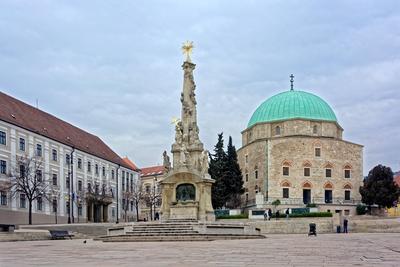 Pécs,  Gázi Kászim pasa dzsámija és a Szentháromság szobor-stock-foto