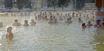 Bükfürdő, sok ember fürdik gőzölő termálvízben a külső medencében-stock-foto