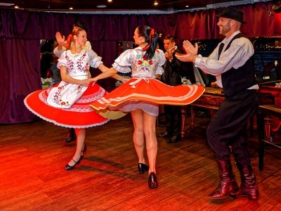 Magyar folklor, népitánc együttes, két lány táncol együtt magyar mintás öltözékban-stock-photo