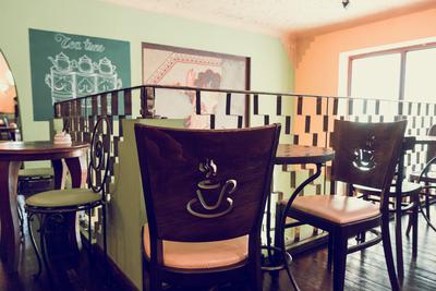 Teaház belső székekkel és asztalokkal, fali dekorációval-stock-foto