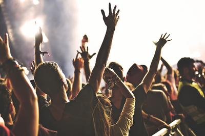 Rear view of crowd with arms outstretched at concert-stock-photo
