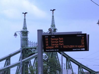 Budapest, 2014. április 13.Az utazóközönséget szolgáló elektronikus információs jelzõtábla a Szent Gellér tér villamosmegállaójában. Háttérben a Szabadság híd részlete.-stock-foto