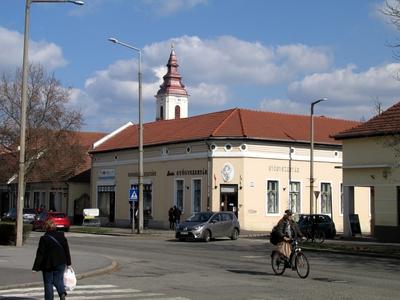 Sárospatak, 2016. március 16.Biciklizõ férfi és gyalogos nõ a Rákóczi úton, a Kossuth Lajos utca keresztezõdésében. Háttérben a református templom tornya.-stock-foto