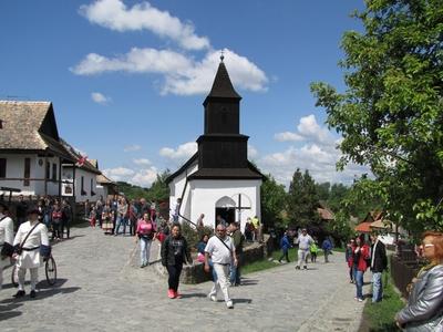 Hollókõ, 2016. május 16.Pünkösdi népünnepi hangulat a hollókõi ófalu fõutcájában. Szemközt a világörökség részét képezõ ófalu Tours-i Szent Mártonról elnevezett temploma. A fából és vályogból készült kicsiny fatornyos római katolikus templomot 1889-ben közadakozásból építtette a falu lakossága.-stock-foto