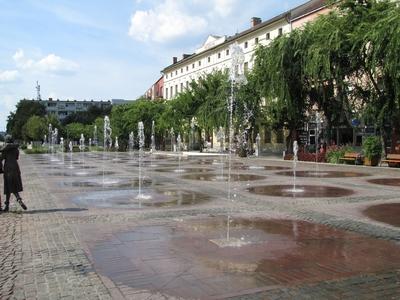 Szolnok, 2016. szeptember 3.A Kossuth tér, Szolnok fõtere szökõkútjaival. Balra a Sétáló ifjú pár szobor részlete. Kligl Sándor alkotása 2008-ból.-stock-foto