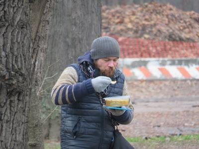 Poor man eating freely distributed food - Budapest-stock-foto