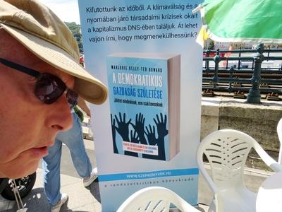 Man watching "The Birth of a Democratic Economy" book at the Budapest Book Festival.-stock-photo