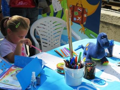 Little girl draws a dino at the Budapest International Book Festival.-stock-photo