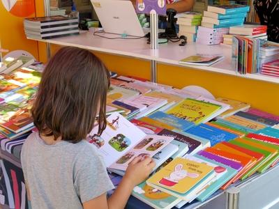Little girl looking at a storybook at the Budapest International Book Festival-stock-foto