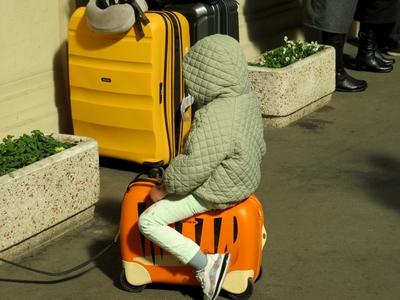 Ukrainian refugee Child riding suitcase - Budapest-stock-foto