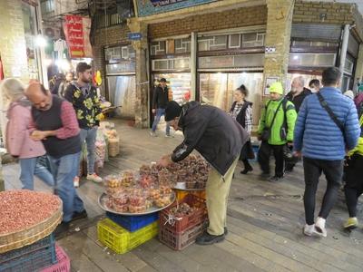 A man selling seeds, fruits and vegetables in Tehran's Grand Bazaar-stock-photo