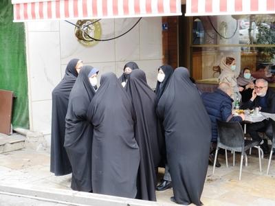 Iranian women in burqas and hijabs outside a cafe - Tehran-stock-foto