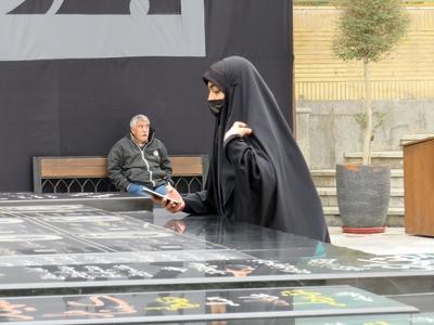 Woman wearing hijab photogtaphing Iranian nuclear physicists' graves - Tehran-stock-foto