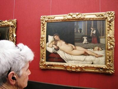 A tourist admires a painting by Tiziano Vecellio - Venus of Urbino - Uffizi Gallery - Florence-stock-foto