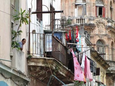 Havana, 25 January 2015Havana house with drying clothes and looking woman from balcony.Havannai lak?h?z sz?rad? ruh?kkal, ?s balkonr?l kin?z? asszonnyal.-stock-foto