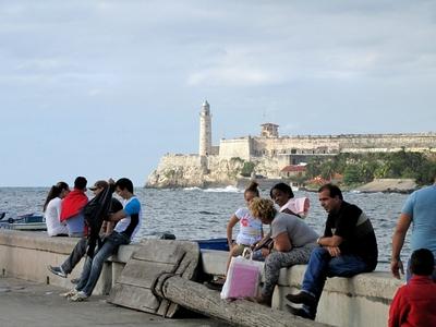 Havana, 25 January 2015Cubans at the entry of Havana harbor with the Morro fortress walls behind them.A Morro er?d?tm?ny falai a havannai kik?t? bej?rat?n?l. A Morro h?rom kir?lya (Castillo de los Tres Reyes Magos del Morro) n?vre keresztelt v?rat Juan Bautista Antonelli m?rn?k tervezte 1585-ben. A v?rfal alatt a kik?t?i szoros l?that?.Pihen? kubaiak a Morro er?d?tm?nnyel szemk?zti parton a havannai kik?t? torkolat?n?l. A Morro h?rom kir?lya (Castillo de los Tres Reyes Magos del Morro) n?vre keresztelt v?rat Juan Bautista Antonelli m?rn?k tervezte 1585-ben. A v?rfal alatt a kik?t?i szoros l?that?.-stock-photo