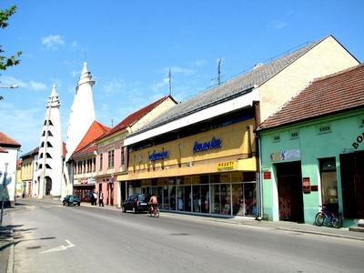 Szigetv?r, 2009. j?nius 15.A szigetv?ri f? ?t, a J?zsef Attila utca Makovecz Imre tervezte (1985) Vigad? Kultur?lis K?zpont toronykapuival, tov?bb? ?zletekkel, lak?h?zakkal.-stock-foto