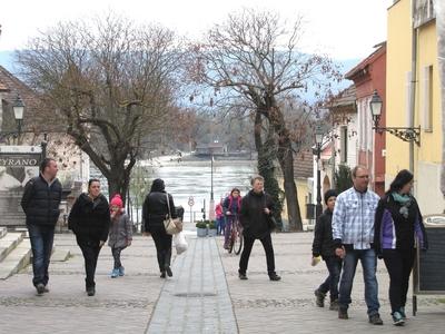 V?c, 2016. m?rcius 27.S?t?l? emberek a v?ci Duna partra vezet? utc?ban. Szemben, a tuls? parton a Szentendrei-sziget l?that?.-stock-foto