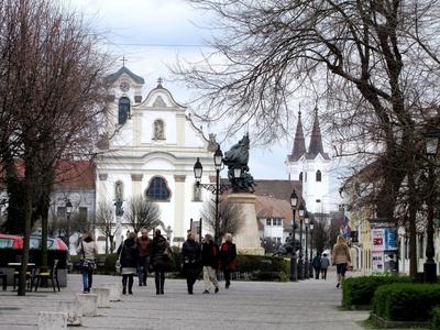 V?c, 2016. m?rcius 27.S?t?l?k V?c f?ter?n, a M?rcius 15. t?ren. Szemben a Szent Mih?ly Domonkos rendi templom (XVIII. sz.),  a M?rcius 15. t?r gy?ngyszeme. El?tte az I. vil?gh?bor?s eml?km?. Jobbra h?tul a Feh?rek temploma.-stock-foto