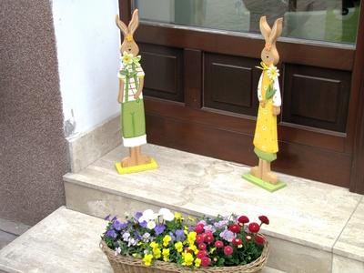 V?c, 2016. m?rcius 27.H?sv?ti nyuszi figur?k ?s vir?gos kos?r egy v?ci ?zlet el?tt.-stock-foto