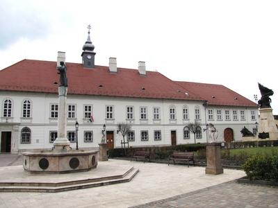 V?c, 2016. m?rcius 27.Az irgalmas k?h?z a M?rcius 15. t?ren. A m?eml?k ?p?let a XVIII. sz-b?l sz?rmazik. A t?ren a Testv?rv?rosi k?t, oszlop?n Evang?lista J?nos szobra. Jobbra az I. vil?gh?bor?s eml?km?.-stock-foto