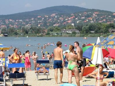 Velence, 2014. augusztus 9.Strandol?k a Velencei-t? partj?n, a Velence Korz? elnevez?s? ?j partszakasz?n, melyet 2014 nyar?n nyitottak meg. H?tt?rben a sukor?i domboldal.-stock-foto