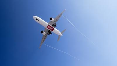 Leszálló Emirates repülő vortex csíkkal a kék égbolton-stock-foto