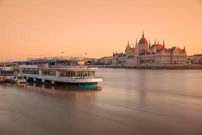 Hungarian parliament and boat. Amazind morning lights with blurred water.-stock-photo