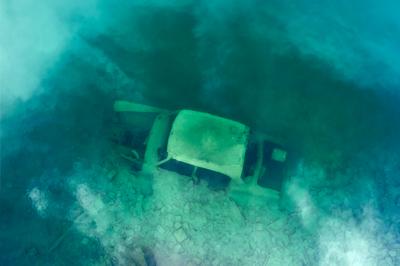 Erdokertes trout lake with broken car-stock-foto