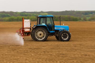 A farmer spraying with a Landini Evolution 9880 tractor-stock-photo