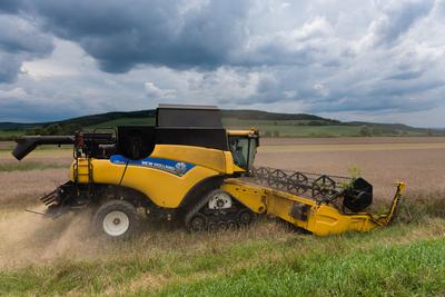 Farmers are harvesting with a New Holland CR9080 combine on a cloudy day.-stock-photo