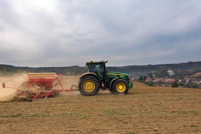 A farmer sowing with a John Deere tractor and a Horsch Pronto 4dc seeding machine. It's a panning shot, that cause the blurry background.-stock-foto