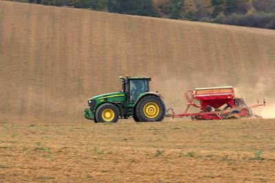 A farmer sowing with a John Deere tractor and a Horsch Pronto 4dc seeding machine. It's a panning shot, that cause the blurry background.-stock-foto
