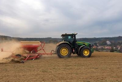 A farmer sowing with a John Deere tractor and a Horsch Pronto 4dc seeding machine. It's a panning shot, that cause the blurry background.-stock-foto