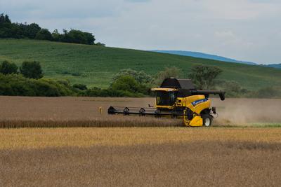 Farmers are harvesting with a New Holland CR9080 combine on a cloudy day.-stock-photo