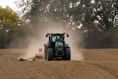 A farmer sowing with a John Deere tractor and a Horsch Pronto 4dc seeding machine.-stock-photo