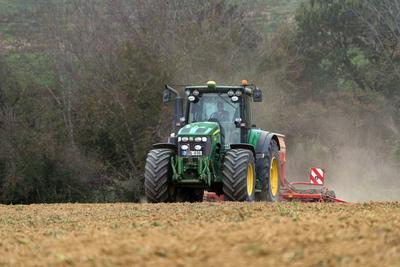 A farmer sowing with a John Deere tractor and a Horsch Pronto 4dc seeding machine. It's a panning shot, that cause the blurry background.-stock-foto