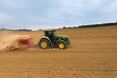 A farmer sowing with a John Deere tractor and a Horsch Pronto 4dc seeding machine. It's a panning shot, that cause the blurry background.-stock-foto