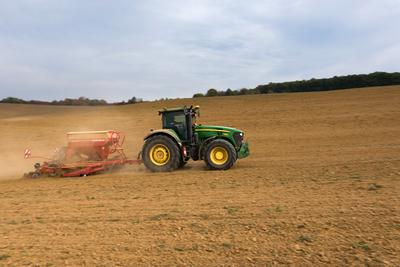 A farmer sowing with a John Deere tractor and a Horsch Pronto 4dc seeding machine. It's a panning shot, that cause the blurry background.-stock-foto
