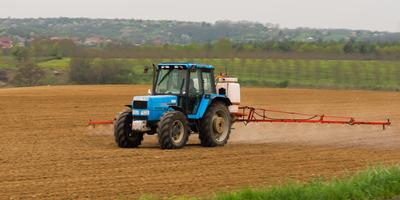 A farmer spraying with a Landini Evolution 9880 tractor. It's a panning shot, that's cause the blurry in the back and foreground.-stock-foto