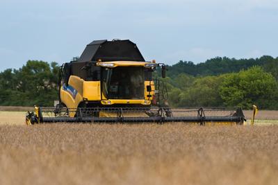 Farmers are harvesting with a New Holland CR9080 combine on a cloudy day.-stock-photo